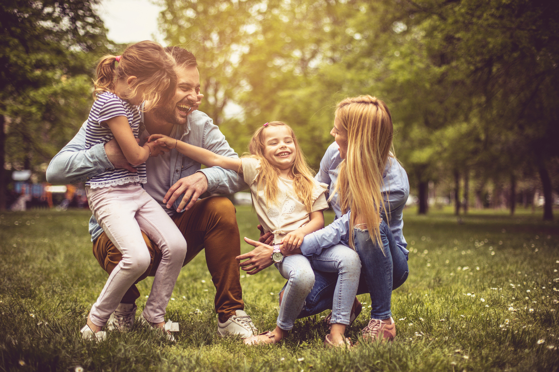 Glückliche junge Familie beim Spielen im Park.