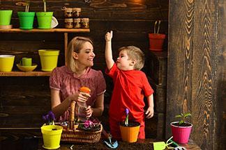 Mutter und Kind pflanzen Blumen ein