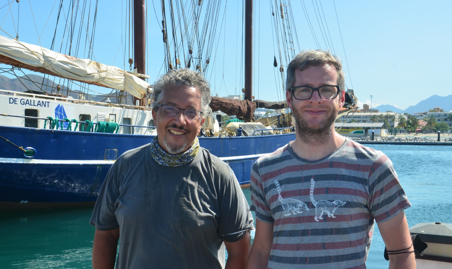 Zwei Mitarbeiter der Rösterei Segelwerk stehen lächelnd in einem Hafen