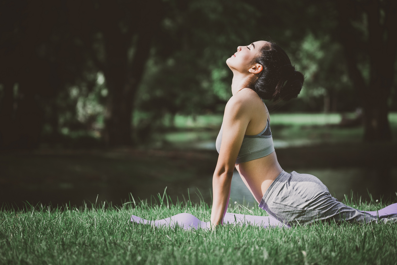 Gesunde Asiatin beim Yoga im Park