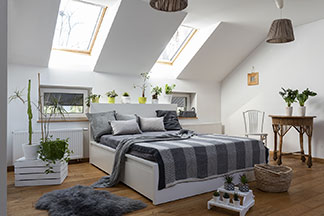 Ein großes freistehendes Bett lädt im Schlafzimmer zum Relaxen ein.