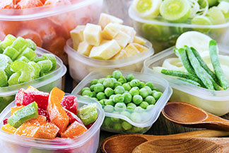 Viele Vorratsdosen mit verschiedenem Gemüse und Obst gefüllt.