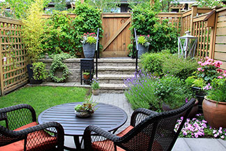 Gartenmöbel umgeben von vielen verschiedenen Pflanzen.