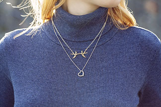 Eine Frau trägt Silber-Schmuck um den Hals.