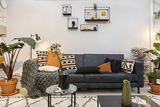Man sieht ein gemütliches Wohnzimmer mit großer Couch