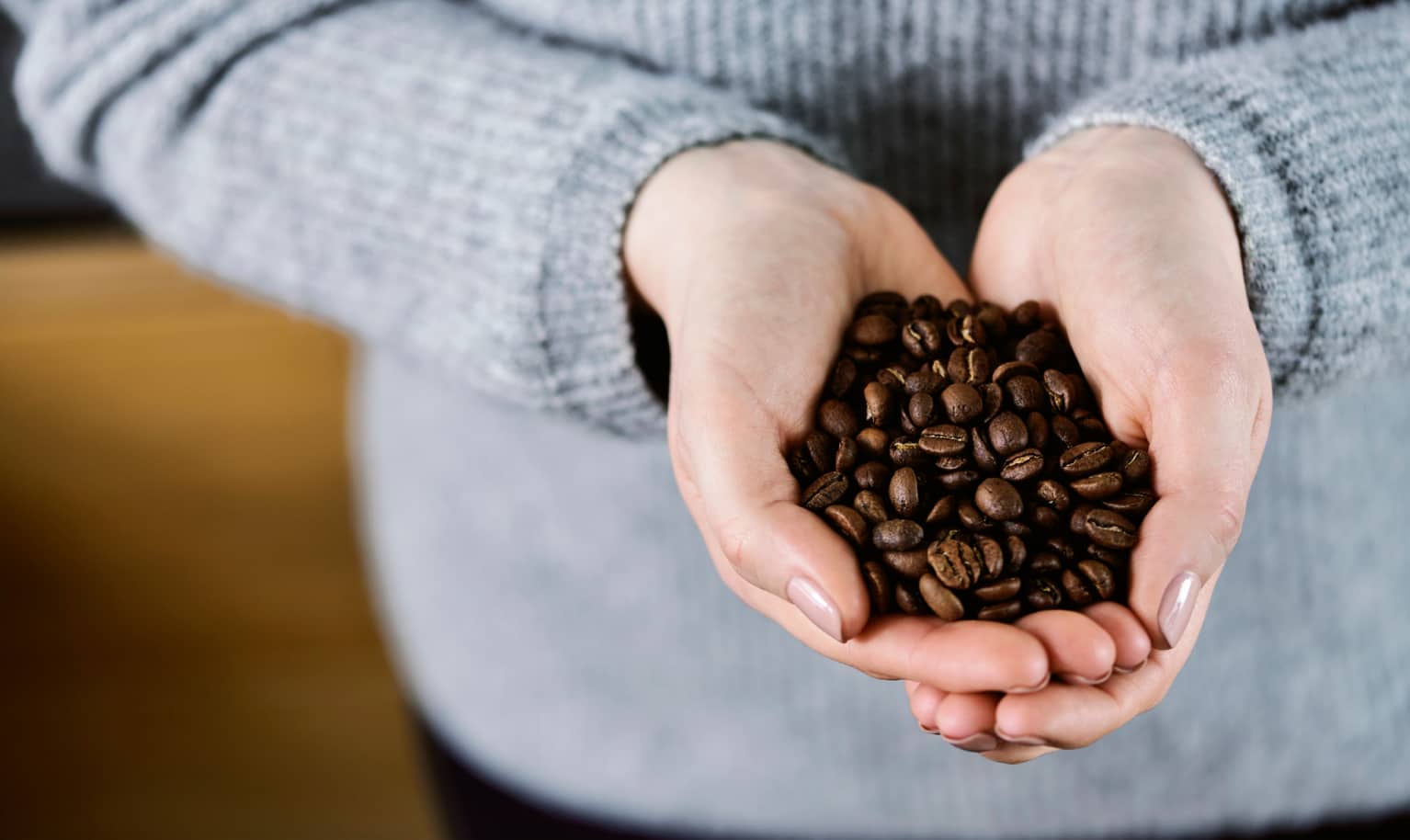 Kaffeebohnen werden in den Handen gehalten