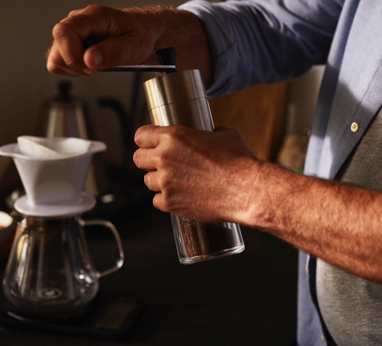 Kaffee wird mit einer Handmühle gemahlen, KH