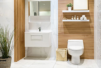 Ein Badezimmer mit einem rechteckigen Waschtisch, neben dem eine Toilette mit ovalem, weißem Toilettendeckel steht.