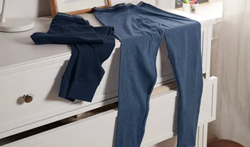 Absolut Atmungsaktiv: Auf einer Kommode liegen zwei lange Unterhosen in blau und grau.