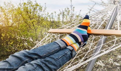 Ein Teenager sitzt in einer Hängematte und trägt eine Strumpfhose unter der Jeans.