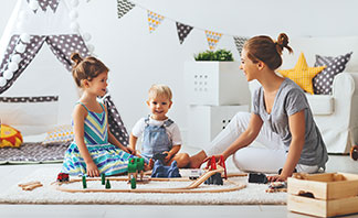Eine Familie spielt im Wohnzimmer.