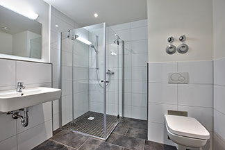 Helle Wände und ein grauer Fliesenfußboden lassen das Badezimmer besonders modern wirken.