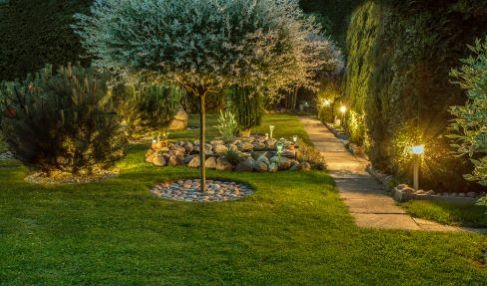 Gartenbeleuchtung mit Solar-Technik: Eine Reihe von Gartenlampen beleuchten einen Weg durch den Garten.