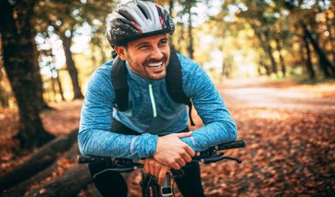 Ein Mann trägt ein blaues Langarmshirt mit gelben Reißverschluss zum Fahrrad fahren.