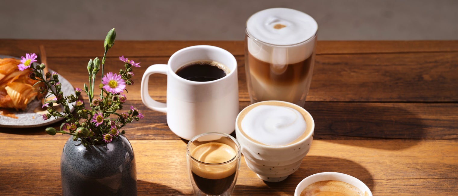 Vase und Kaffeetassen auf Holztisch','Enter picture alt'}
