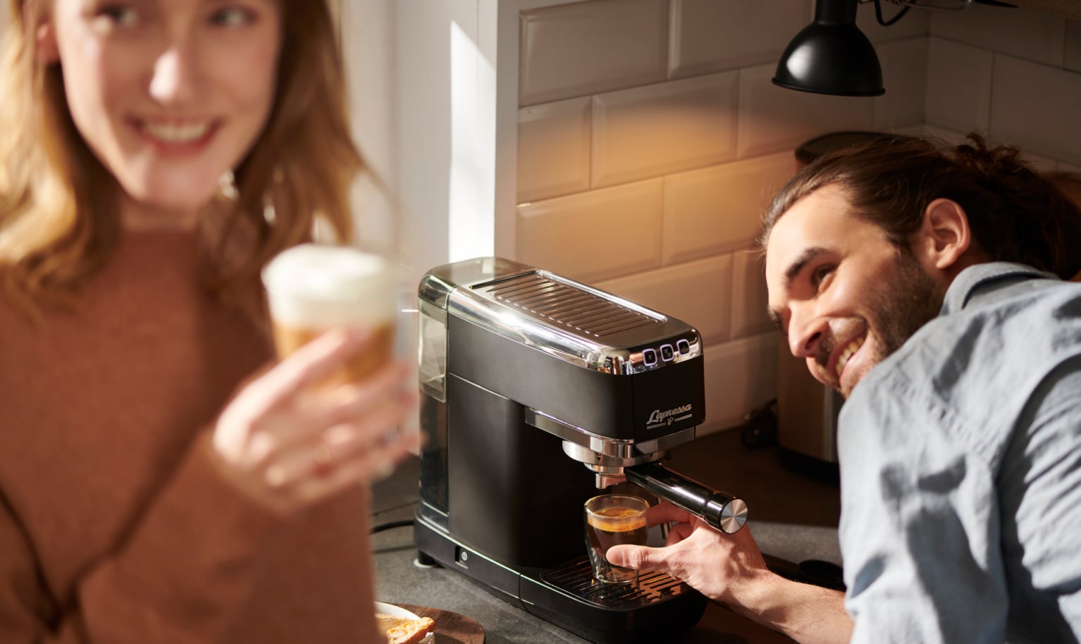 Eine Frau trinkt Kaffee, der mit der Siebträgermaschine gebrüht wurde.