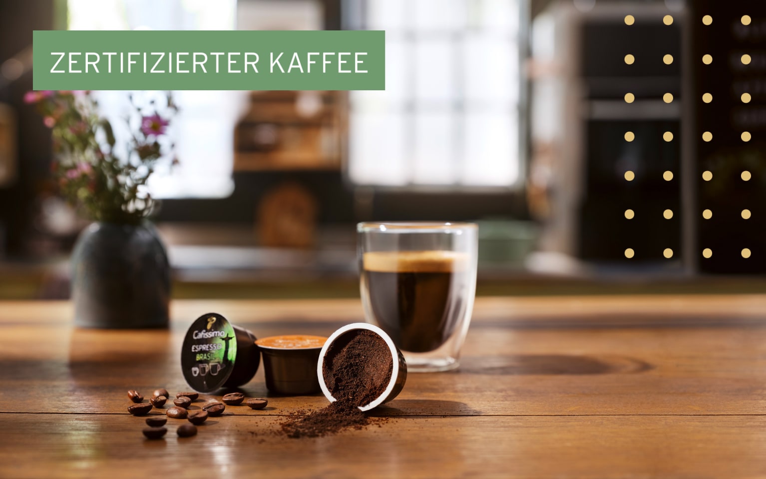 Glas Kaffee steht mit zwei Cafissimo Kapsen auf einem Tisch