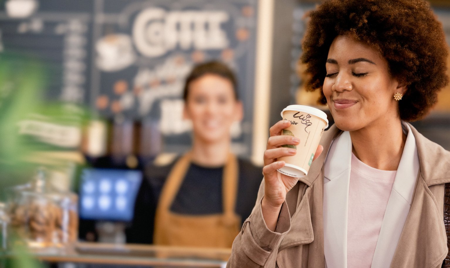 Frau genießt To Go Kaffee in Bäckerei
