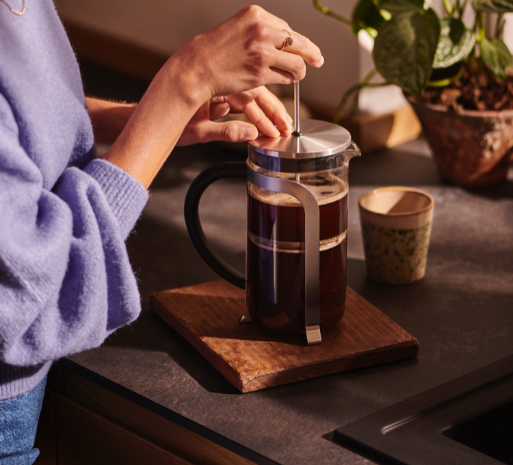 Stimmungsvolles Bild der manuellen Zubereitung mit einer Siebstempelkanne. Denn von Siebstempelkanne über Porzellan-Kaffeebereiter bis zu Pour Over, ist hier für jeden etwas dabei.