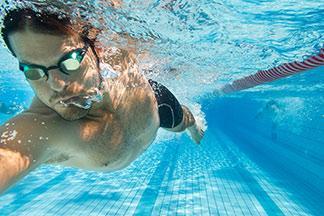 Mann schwimmt mit Schwimmbrille