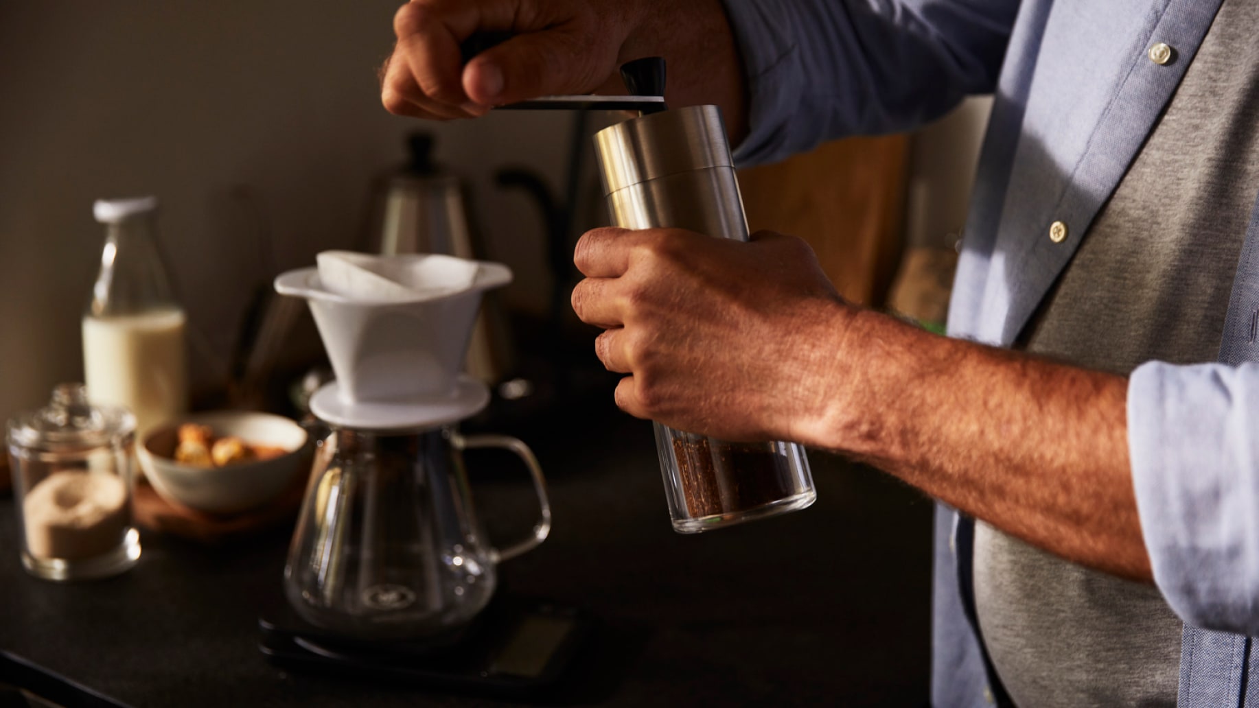 Mann bereitet Kaffee mit Kaffeemühle zu