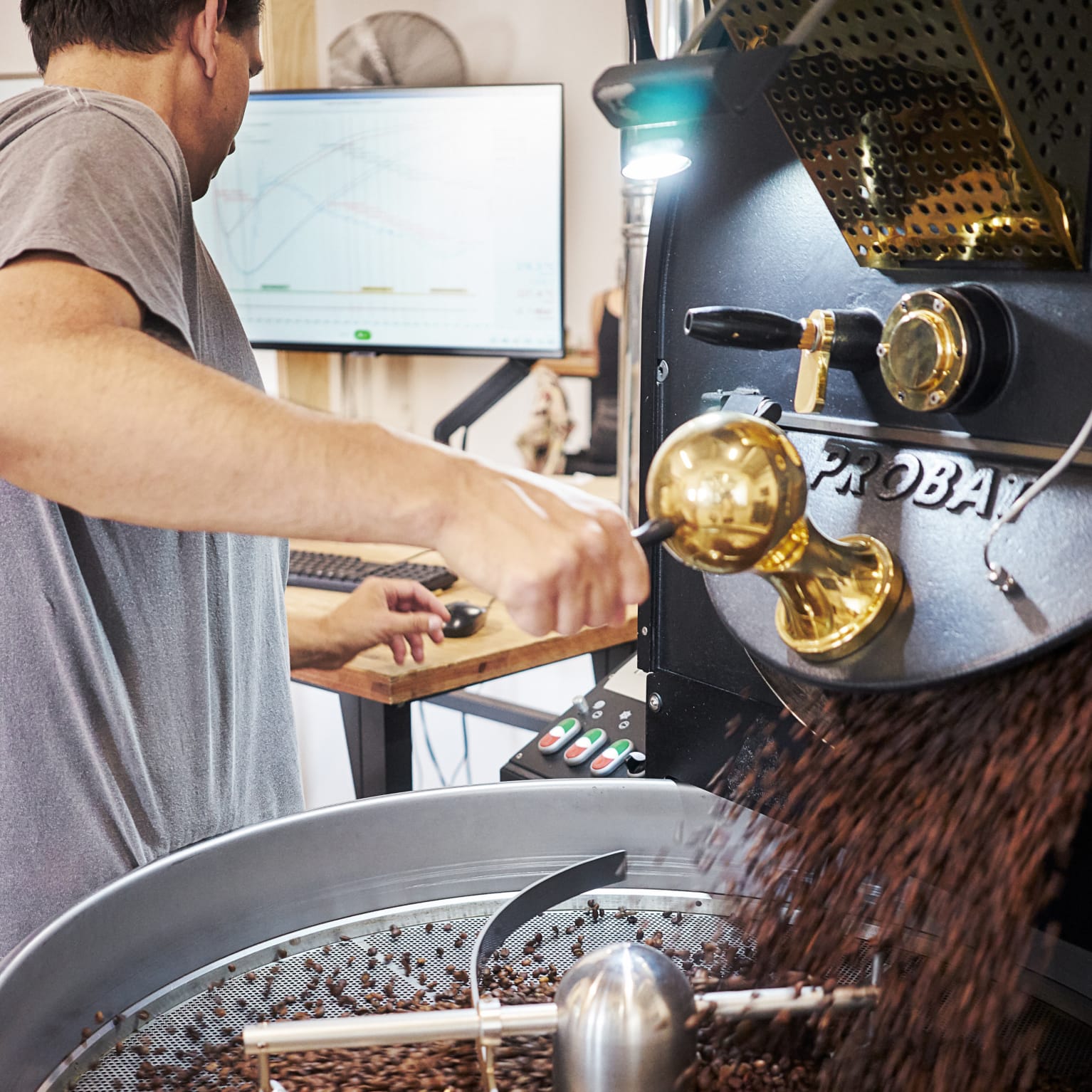 Röstereigründer Karl arbeitet am Röster und füllt Kaffeebohnen um