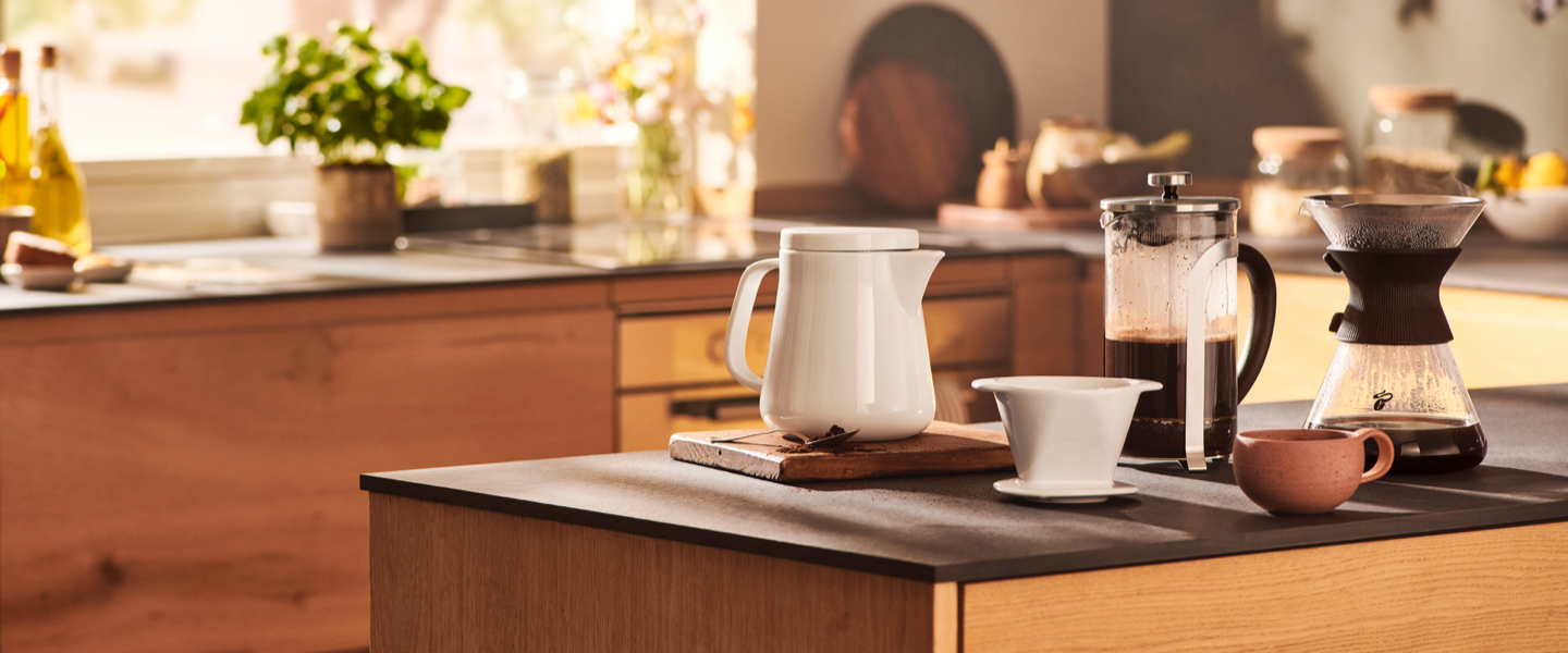 Ein kleiner Junge schaut zu, wie ein Kaffee mit einem Keramikfilter in eine Glaskanne aufgebrüht wird. Das ist die Schwerpunkt Seite der Manuellen Zubereitung.