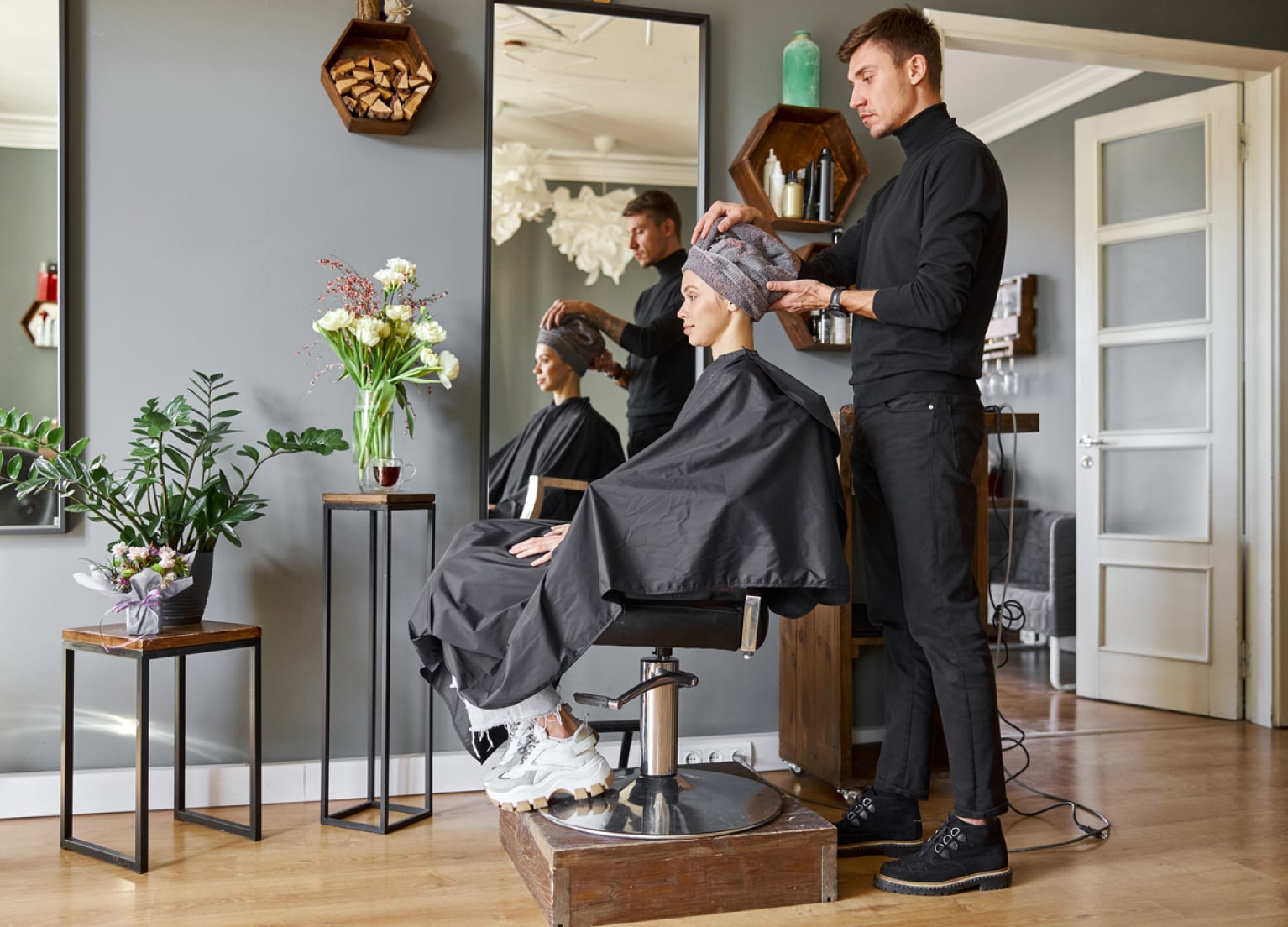 Friseur und Kundin im Stuhl in einem Friseurladen