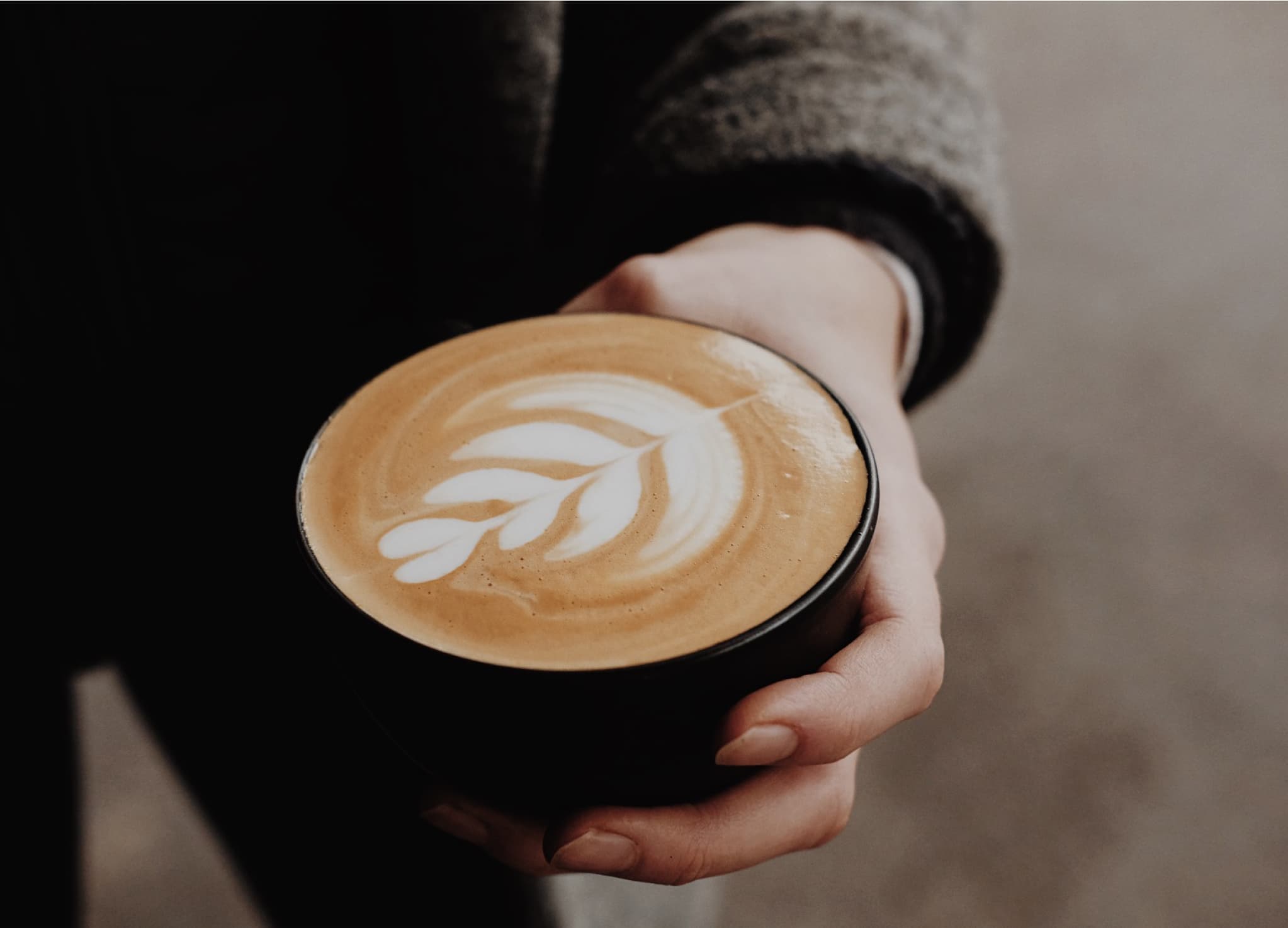 Nahaufnahme von Capuccino Tasse mit Latte Art auf Holztisch