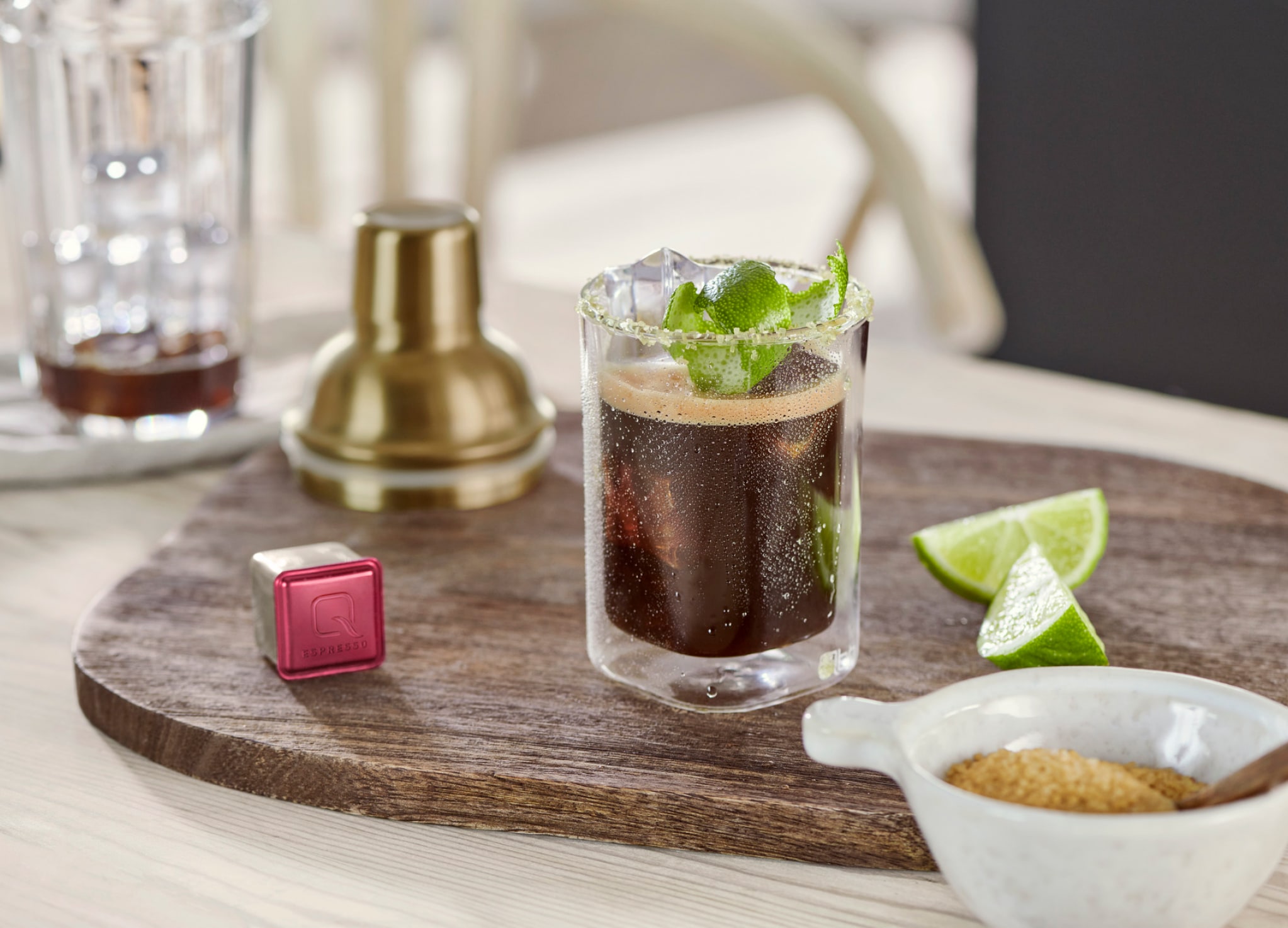 Kaffee steht mit Cocktail-Zubehör und Limettenscheiben auf einem Tresen