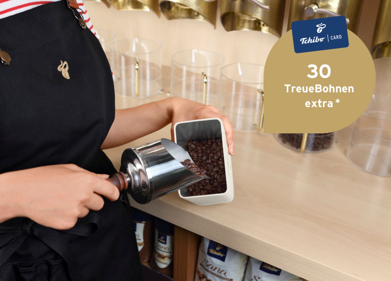 Ein Filialmitarbeiter füllt in einer Tchibo-Filiale Kaffee in eine Dose