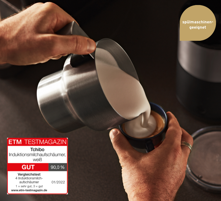 Milchschaeum wird aud dem Induktions-Milchschäumer auf einen Kaffee geschüttet.