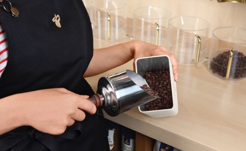 Kaffeebohnen werden in einer Tchibo Filiale in die Kaffeedose gefüllt