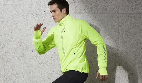 Ein Mann ist in einer neongelben Sportjacke joggen.