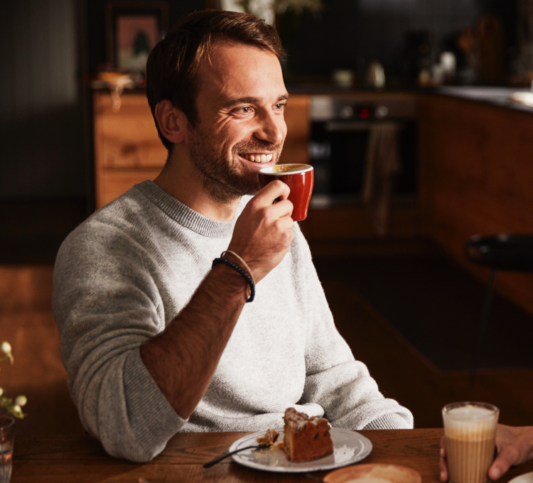 Stimmungsvolles Bild, bei dem ein Mann aus seine Tasse Kaffee genießt.
