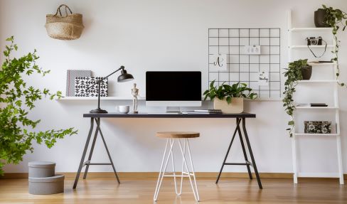 Gute Qualität für Ihren Schreibtisch: Ein Schreibtisch steht an der Wand, davor ist ein Hocker.