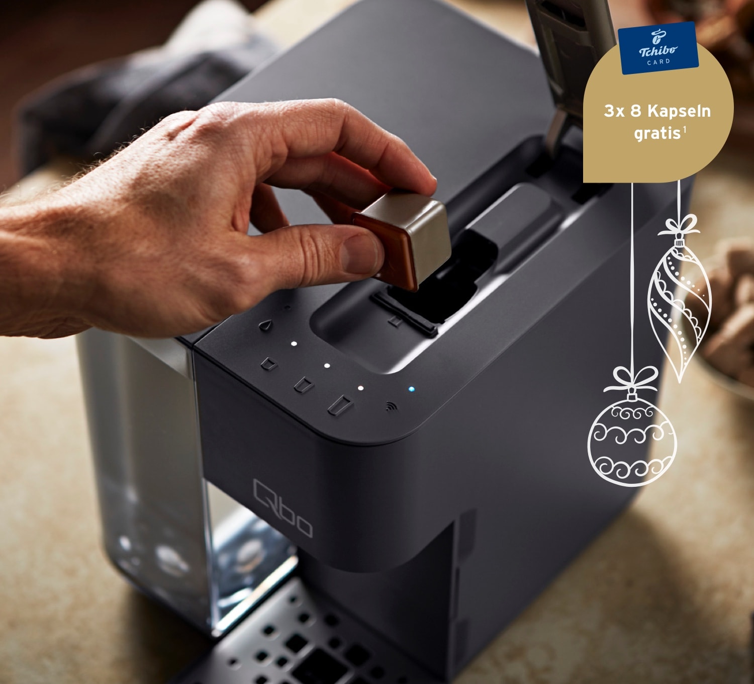 Ein Mann legt eine Qbo Kaffeekapsel in das Kapselfach einer Qb Touch in Basalt Grey