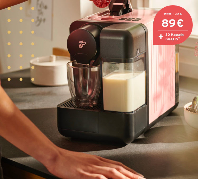 Eine Frau trinkt genüsslich einen Latte Macchiato