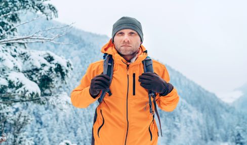 Ein Mann mit Bart trägt eine gelbe Mütze: Das Sportaccessoire ist stylisch und schützt auch vor zu intensiver Sonneneinstrahlung.