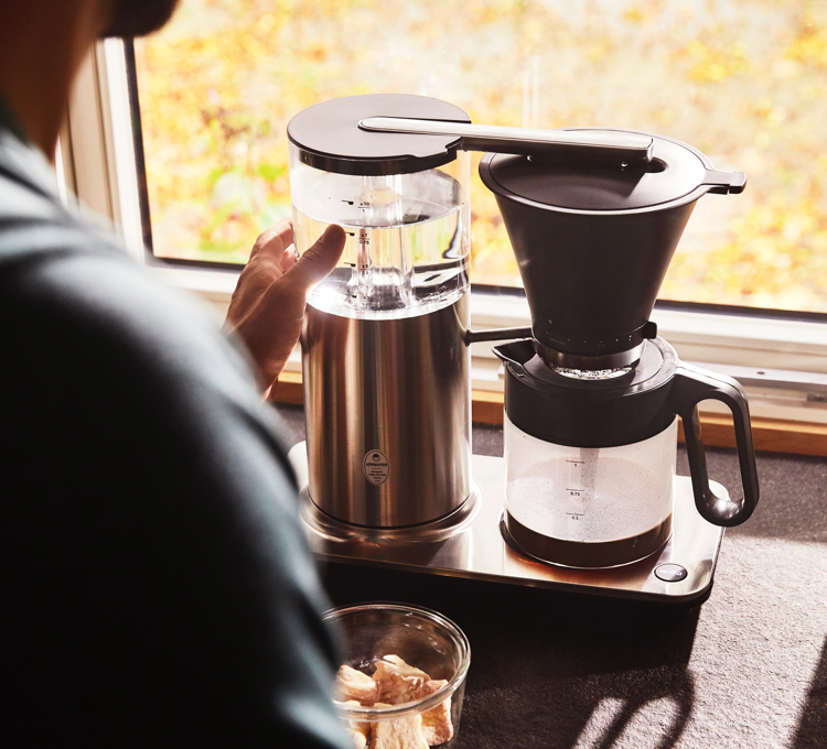 Mann brüht Kaffee mit einer Filterkaffeemaschine von WILFA auf