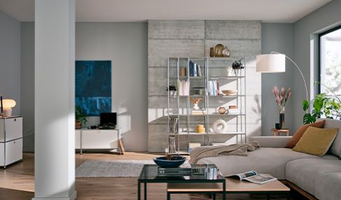 Ein helles Sofa steht in einem modernen Wohnzimmer.