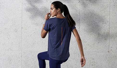 Super modisch: Eine Frau trägt ein dunkelblaues Sportshirt zum Aufwärmen vor dem Workout.