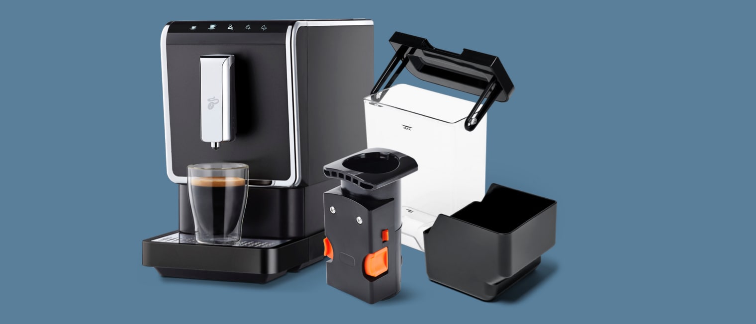 Verschiedene Kaffeemaschinen, Milchkännchen und Tassen auf einer Küchenablage