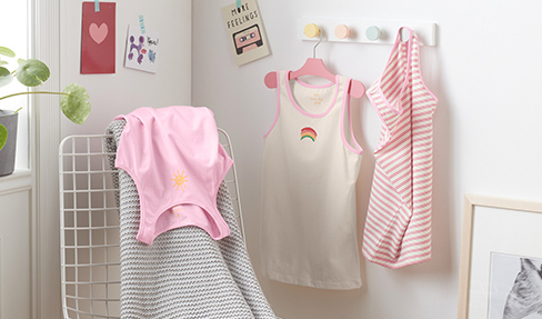 Baby- und Kinderkleidung aus schonenden Materialien: Kinderkleidung aus Naturmaterialien hängt über einem Stuhl.