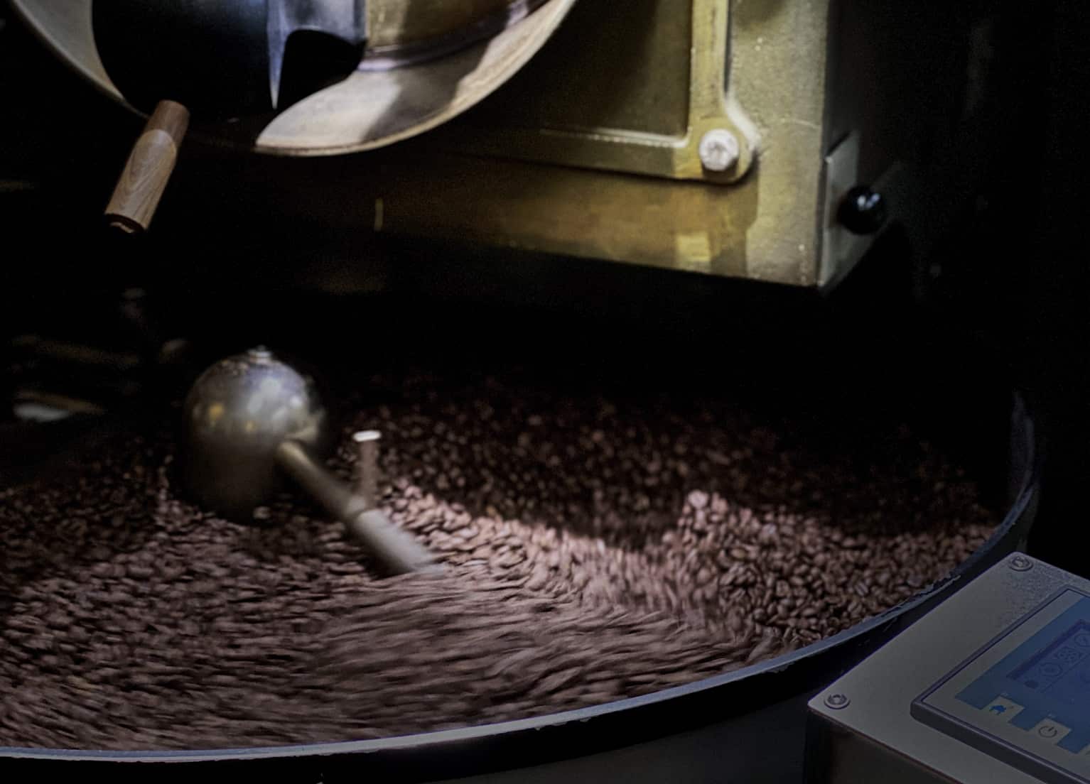 Nahaufnahme Kaffeeröster mit Blick auf die Kaffeebohnen, die sich im Kühlsieb drehen