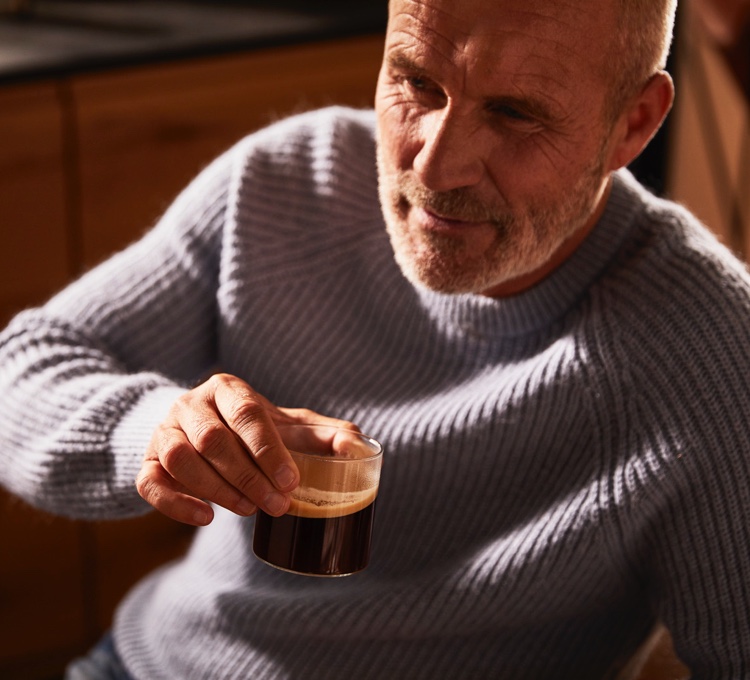 Ein Mann trinkt genüsslich einen Kaffee.