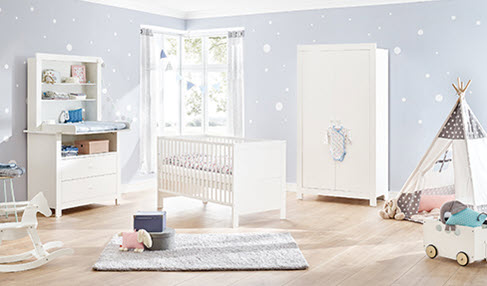 Ein altersgerechtes Zimmer: Ein Babyzimmer ist mit einem Babybett, einer Wickelkomode und Kinderspielzeug ausgestattet.
