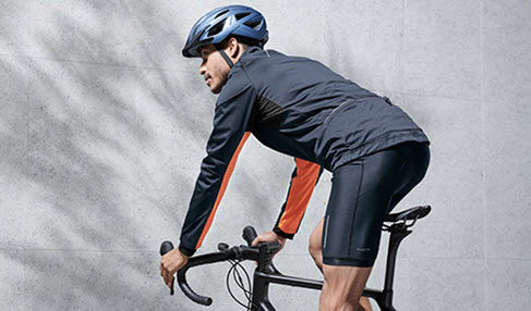 Ein Mann fährt Fahrrad. Er trägt dabei einen schwarzen Fahrradhelm.