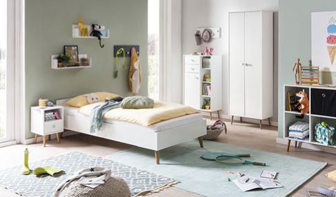 Ein Kinder- oder Teenagerzimmer ist mit Fähnchen und Dekoration geschmückt. In der Mitte steht ein Bett.
