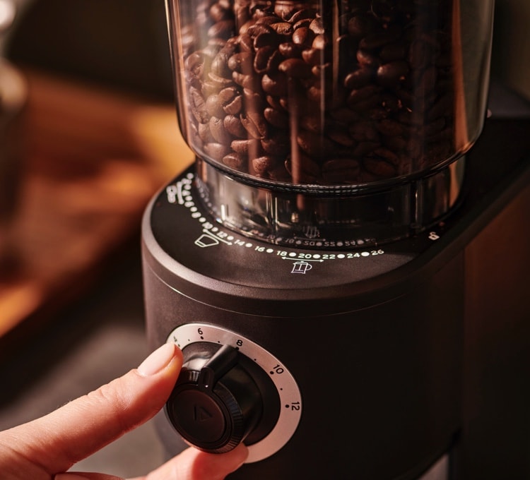 Gemahlenes Kaffeepulver im Auffangbehälter einer elektrischen Kaffeemühle